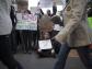 Przechodnie mijają protestujących na Wall Street