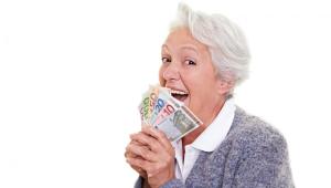 Seniorak z plikiem banknotów w dłoni, mat. shutterstock